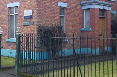 The Hamill, Wallace & Hardy LLP office building at 2 Demesne, Dundalk, a red-brick period building with a black railed frontage.